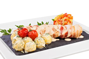 Restoran menüsü için yemek fotoğrafçılığı. Beyaz arka planda izole edilmiş. Beyaz bir tabak üzerinde siyah mermer tahta üzerinde et, pastırma ve sebze ile genç patates