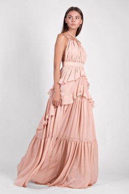 Stüdyoda pembe elbiseli güzel bir kadın. 