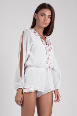 Stüdyoda poz veren, çiçekli tulum giyen güzel bir kadın. 