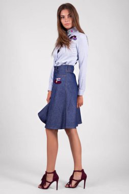 Stüdyoda bluz ve etek giymiş güzel bir kadın. 