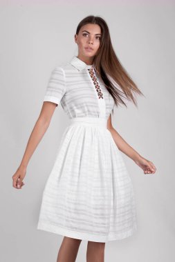 Stüdyoda beyaz elbise giymiş güzel esmer kız. 