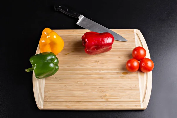 Wooden cutting board with vegetables and a knife