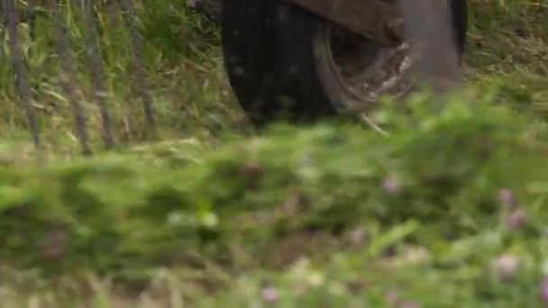 Mähdrescher-Maschinenwagen sammelt gemähtes Gras auf Feld ein — Stockvideo