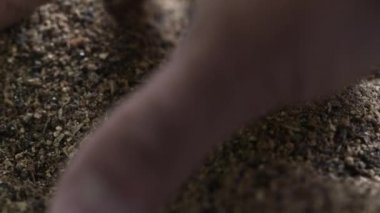 Adamın çantasından kahverengi tahıl kapmak ve parmaklarını ağır çekimde geçer