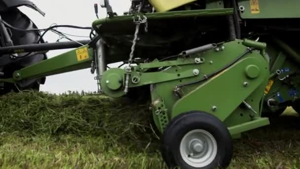 Combineren van harvester machine vervoer verzamelt gesneden gras op boerderij marge — Stockvideo