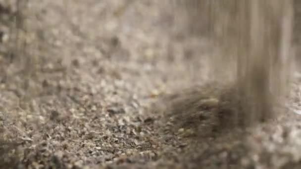 Grains écrasés tombant au hasard dans un sac avec mouture brune au ralenti 