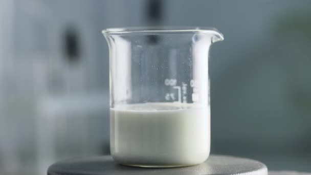 Лабораторные эксперименты. Проверка молока. Реакция смешивания реагентов и молока в стекле — стоковое видео