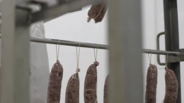 Adam alt raf üzerinde sosis dağıtır. Fabrika yapma et