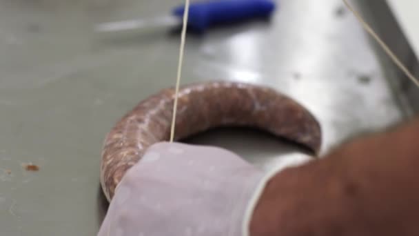 Der Arbeiter packt Fleisch in Schale und bindet es mit einem Netz zusammen. Wurstherstellung — Stockvideo