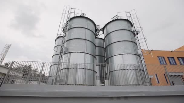 Los tanques de agua permanecen uno al lado del otro cerca de la fábrica — Vídeo de stock