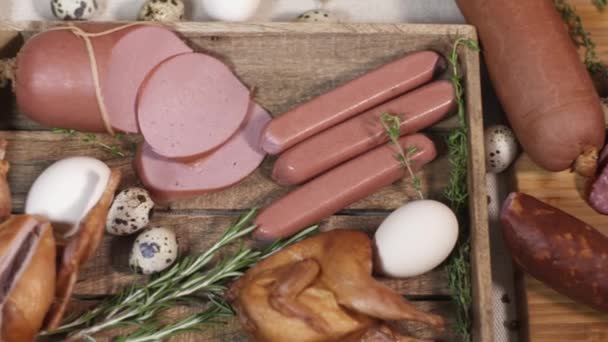 Вкусные мясные продукты на нарезке доски на скатерти — стоковое видео