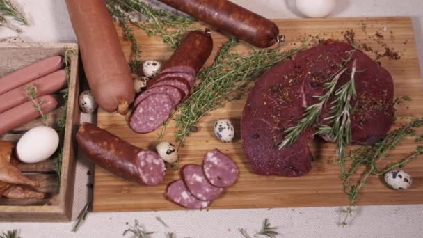 Натуральные мясные продукты на разделочной доске на скатерти — стоковое видео