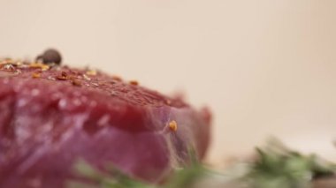 Tablo üzerinde ham taze kırmızı sığır et parçası üzerinde düşen baharat
