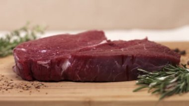 Biberiye ve baharatlar ile tabloda çiğ kırmızı biftek parçası