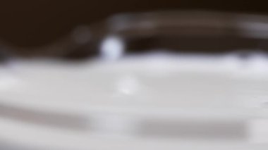 Cam yüzeyde dalgalanma drib taze süt düşüyor