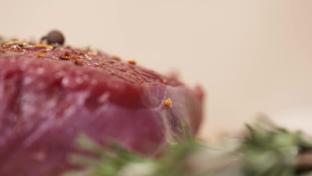 Bit av raw rött kött på bordet med örter och kryddor — Stockvideo