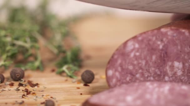 Taze kielbasa otlar yanında kesme tahtası üzerinde bıçak ile dilimlenmiş — Stok video