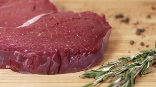 Kus syrové červené steak na stole s bylinkami a kořením — Stock video