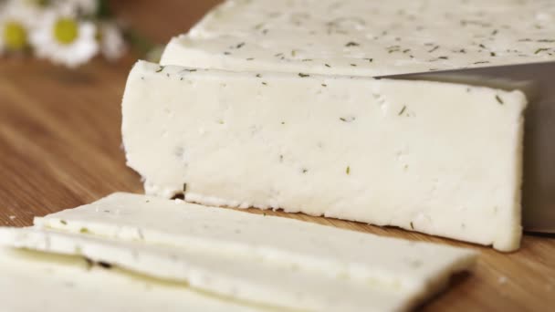 Fresh white cottage cheeze with herbs being cutted with blade on cutting board — Stock Video