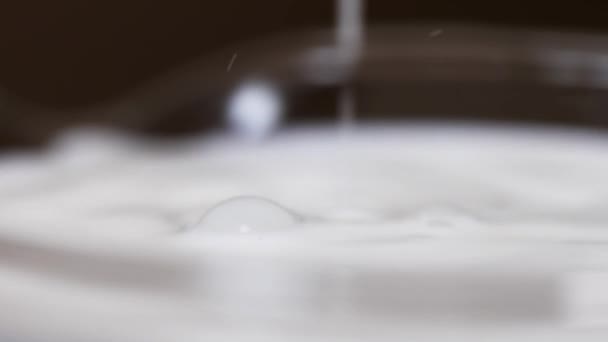 Drib από αγνό γάλα πέφτει σε γυαλιού καθιστώντας κυματισμός σε επιφάνεια — Αρχείο Βίντεο