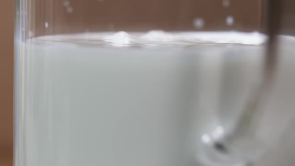 纯牛奶摇在玻璃罐中的字符串, 使飞溅 — 图库视频影像