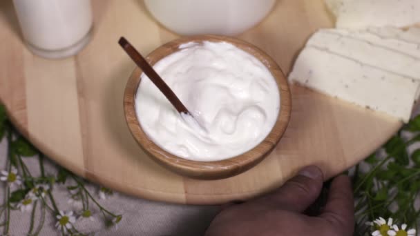 Chef mano masculina gira plato de madera con alimentos lácteos en la cocina — Vídeo de stock