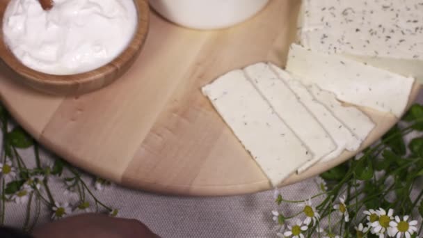 Chef braço masculino vira prato de madeira com alimentos lácteos na cozinha — Vídeo de Stock