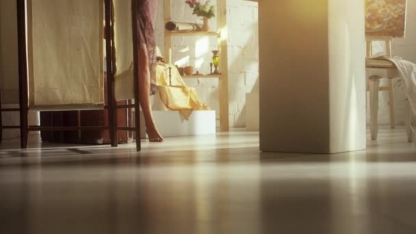 Kvinnan går barfota på avtäckta golv i ljusa rum i dagsljus — Stockvideo