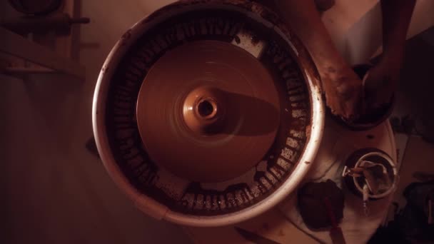 Вращающееся колесо гончаров с руками, наливающими воду и работающими над ней, формируя кувшин . — стоковое видео