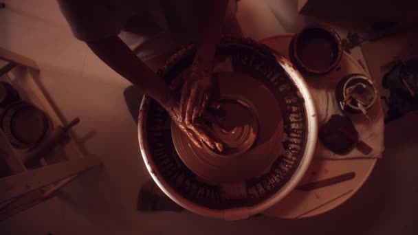 Las manos de las mujeres están trabajando en la rueda de alfarero usando un dedo formando plato de arcilla — Vídeo de stock