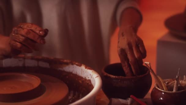 Формування глиняного горщика з гончарним інструментом на обертовому колесі гончарів у студії . — стокове відео