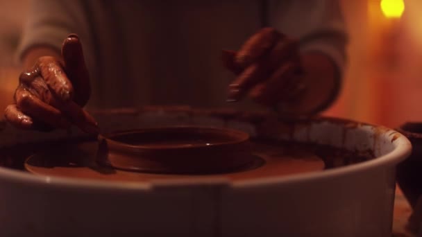 Rueda y manos de alfarero utilizando la herramienta de cerámica para dar forma a una olla de arcilla pequeña . — Vídeo de stock