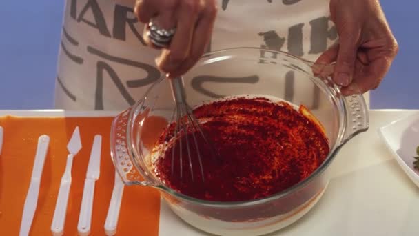 Hand whisking of dark red substance in glass bowl by slow motion — Stock Video