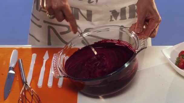 La substance violette se fait fouetter à la main dans une grande casserole en verre ronde — Video