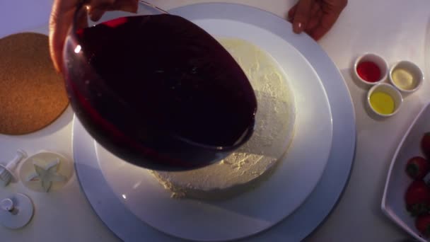 Weißer Kuchen wird mit violetter Sahne bedeckt, die aus einer großen Glasschüssel strömt. — Stockvideo