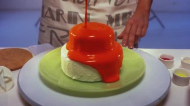 Küçük yuvarlak çift katlı pasta şeklinde turuncu krem ile kaplıdır.