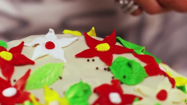 Decoración de la torta con pequeñas flores en forma de estrella de colores en la superficie blanca curvada — Vídeo de stock