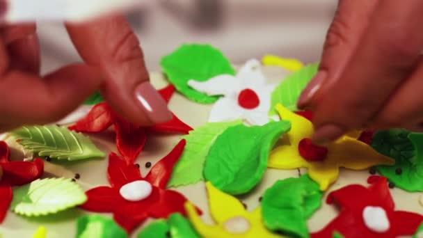 Медленное украшение торта с небольшими искусственными цветными цветами в форме звезды — стоковое видео