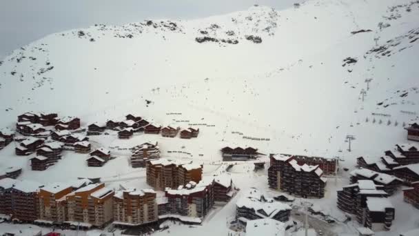 Cidade de esqui de inverno com abundância de esquiadores de corrida é apresentado a partir da vista do céu — Vídeo de Stock