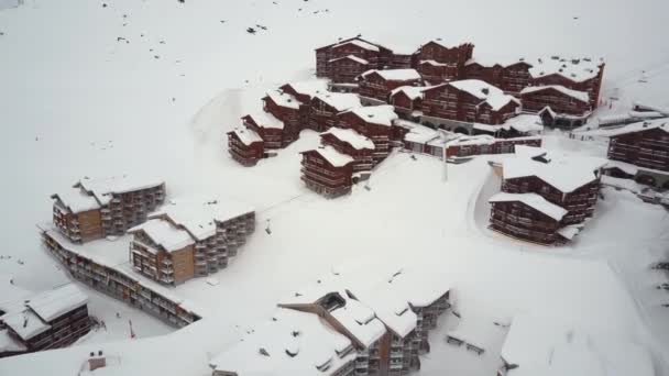 Ski resort from sky view showing cottages, cable ski lifts, tracks and skiers. — Stock Video
