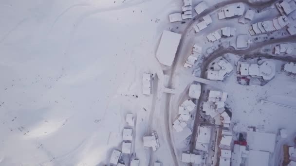 Estación de esquí con vista al cielo con rotación mostrando casas y puntos negros de esquiadores — Vídeo de stock