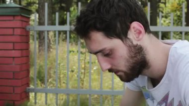 Genç adam açar küçük mavi kadife kutu nikah yüzüğü çitin yanında sakallı