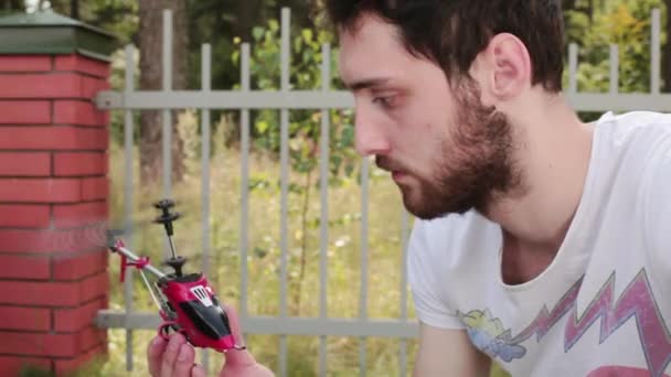 A nyári srác tartja kezében dolgozik nano helikopter, majd kapcsolja ki. — Stock videók