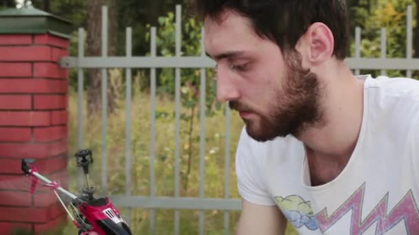 In daylight man holds in hands working nano helicopter and then turns it off. — Stock Video