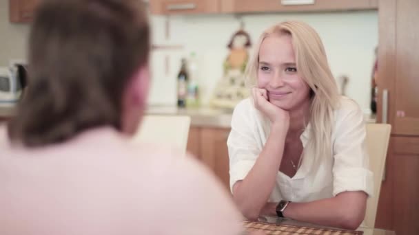 Dvě mladý muž a žena sedí u stolu a mají hezký teplý rozhovor — Stock video