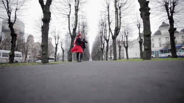 Young couple dances tango in cold empty winter park surrounded by naked trees — Stock Video