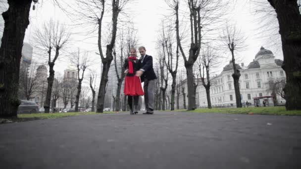Репетиция двух танцоров, игриво играющих в пустом парке среди голых деревьев — стоковое видео