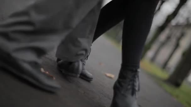 Mans en dames voeten in zwart lederen schoenen verplaatsen in dans op concrete traject — Stockvideo