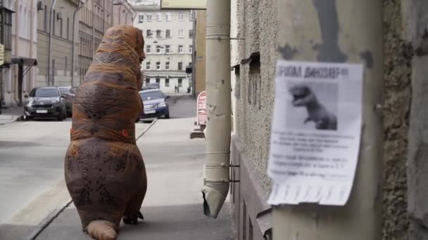 Bizzat t rex maskot şehir sokak kaldırım kameraya uzağa yürüme — Stok video