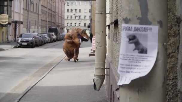 Pessoa em t rex mascote correndo para câmera na calçada da rua da cidade — Vídeo de Stock